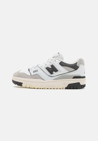 White sneakers with gray and black accents, featuring a textured suede toe, mesh and leather upper, and a thick rubber sole. Model number 550 visible.