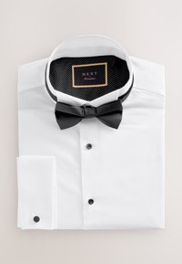 White formal dress shirt with black buttons and cufflinks, black bow tie, and black polka-dot inner collar labeled "NEXT Occasion."