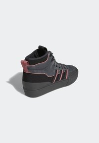 Zapatillas altas en negro y gris con detalles en rosa, parte superior de tela texturizada, cierre de cordones, suela de goma y cuello acolchado.