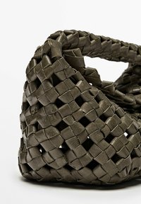 Vävd läderhandväska i mörk olivgrön med en texturerad yta. Har en unik, flexibel form och stabila handtag.