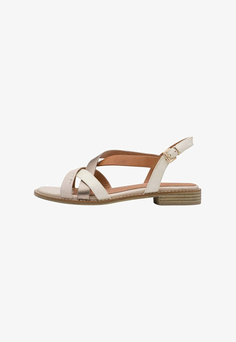 Sandale à brides beige et métallisée avec un petit talon carré. Elle présente une bride à boucle unique, une semelle texturée et un design croisé sur la partie supérieure.