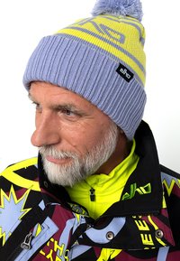 Gehaakte beanie in pastelpaars en geel met een textuur ribbelpatroon, voorzien van een pompon bovenop en een zwart logo-label.