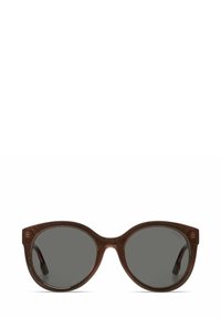 Lunettes de soleil en plastique marron à motif avec des verres ronds et une légère forme œil de chat. Dotées de verres teintés foncés et de montures épaisses.