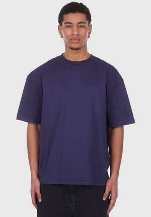 Mørkeblå oversized t-shirt lavet af bomuld, med korte ærmer og et tekstureret logo på brystet. Enkelt design uden mønstre.