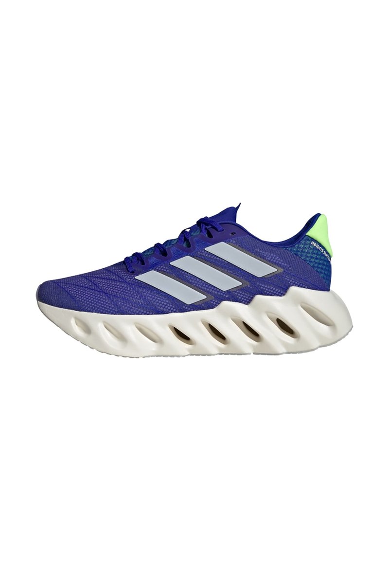 Scarpa da corsa Adidas blu con suola bianca, caratterizzata da fori ritagliati e tre strisce riflettenti argento sul lato.