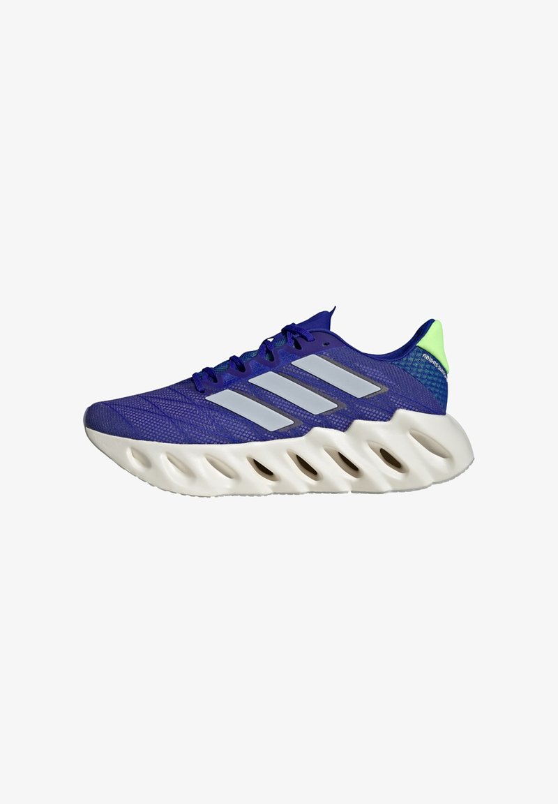Baskets de course Adidas bleues avec semelle blanche, dotées de trous découpés et de trois bandes réfléchissantes argentées sur le côté.