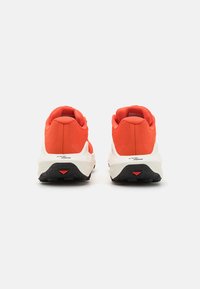 Rode sportschoenen met een bovenwerk van mesh en een gevoerde kraag. De zool is wit met een gestructureerde zwarte rubberen buitenzool en rode accenten.