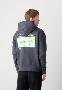 Gray hoodie with a drawstring hood, featuring a large green graphic print on the back with text and abstract design. Cotton blend material.