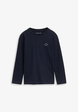 Marineblaues Langarmshirt aus weichem Baumwollstoff. Mit einem kleinen weißen Smiley-Emblem auf der Brust. Klassischer Rundhalsausschnitt.