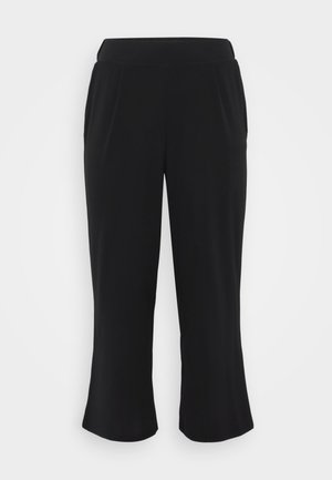 Pantalons noirs raccourcis en tissu lisse et texturé, taille élastique et plis devant. Jambes droites arrivant juste au-dessus de la cheville.