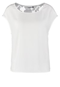 Blouse blanche à manches courtes avec un col rond et des accents en dentelle sur les épaules, présentant une coupe décontractée et une texture lisse.