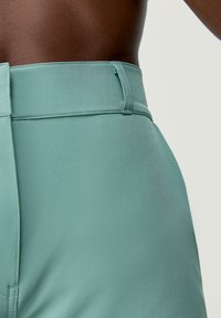 Hoge taille, mintgroene broek met een gladde textuur, minimale stiksels en een zijzipper als sluiting.