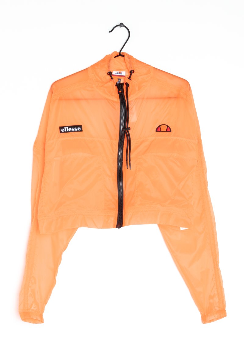 Veste courte orange vif avec fermeture éclair noire et cordons de serrage, patch logo Ellesse sur la poitrine, suspendue à un cintre noir sur fond blanc.