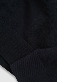 Maglione a maglia di un blu navy scuro con finitura testurizzata, polsini a costine e un design semplice senza motivi visibili o dettagli hardware.