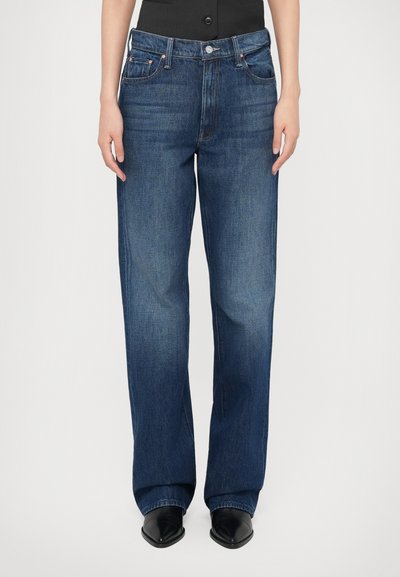 Jean en denim bleu avec une coupe droite, cinq poches et une fermeture à bouton. Le tissu présente une texture lisse et un décoloration minimale.