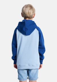 Bluza z kapturem w jasnoniebieskim kolorze z ciemnoniebieskimi rękawami, wykonana z miękkiego materiału. Żebrowane mankiety i dół, prezentująca prosty design.