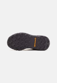 Shoe outsole with a rugged black rubber surface, featuring multidirectional lugs for traction and an embossed orange "Continental" logo.