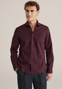 Burgundi spalvos mygtukinė marškinėlie su lygiu audiniu, klasikinio color ir ilgomis rankovėmis, su kontrastinėmis pilkomis mygtukais ir prigludusia forma.