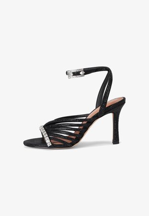 Sandalo nero con tacco alto, decorazioni in strass sulle cinghie e sulla fibbia, dita aperte e tacco a spillo sottile.