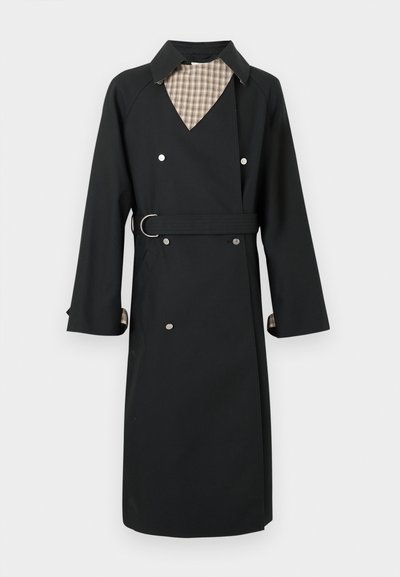Μαύρο μακρύ παλτό τραντσέ με ζώνη στη μέση, ασημένια κουμπιά και μπεζ καρό φόδρα στο εσωτερικό γιακά και μανσέτες.