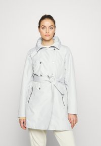 Abrigo trench de color gris claro con diseño de doble botonadura, gran cuello, cintura ceñida con cinturón y bolsillos laterales con cremallera. Tejido suave y resistente al agua.