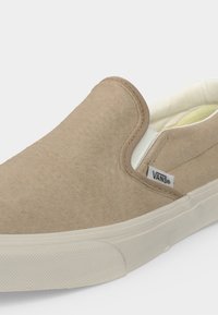 Μπεζ παπούτσι Vans slip-on από σουέντ με λευκή χοντρή καουτσούκ σόλα και επενδυμένο γιακά, με πλαϊνή ετικέτα λογότυπου και απλή υφή πάνω μέρος.