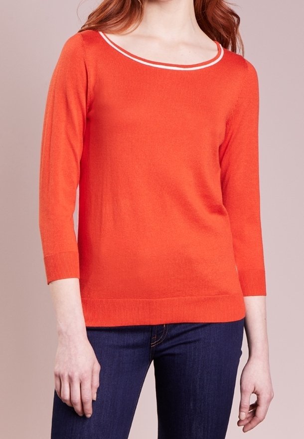 Pull à manches trois-quarts de couleur orange vif avec un col rond blanc. Fabriqué en maille douce, il présente un ourlet ajusté.