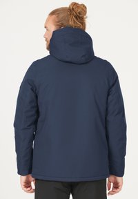 Marineblå isoleret jakke med hætte, glat tekstur og enkelt design. Har en lige pasform og sidelommer.