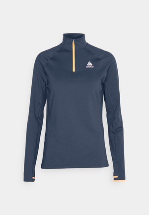 Navy long-sleeve performance top with a quarter-zip collar, orange zipper accent, and white logo on the upper left chest. Smooth texture.