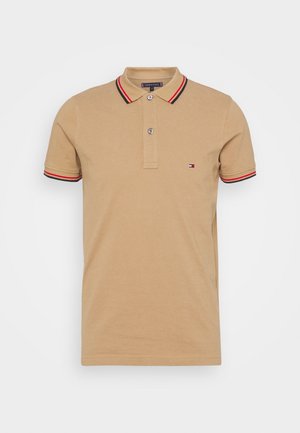 Beige short-sleeve polo shirt with two buttons, black and red stripes on collar and sleeves, and small embroidered logo on left chest.