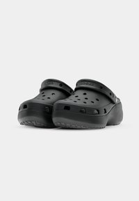 Sabots noirs avec trous de ventilation, semelle texturée et bride de talon pivotante affichant le logo Crocs.