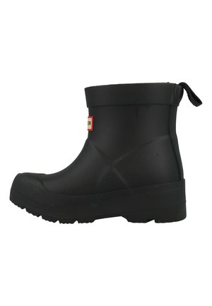 Botte noire en caoutchouc jusqu'à la cheville avec une semelle texturée, un bord surélevé, une languette et un détail de logo blanc. Présente une finition lisse et un bout arrondi.