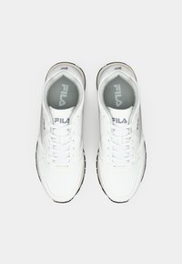 White sneakers with a smooth leather upper, lace closure, and padded collar. Fila logo in gray on the tongue and side. Rubber outsole.