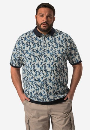 Kortærmet polo t-shirt i lyseblå med blomstermønster i mørkeblå, marinefarvet krave og ribbede manchetter. Casual fit og struktureret stof.