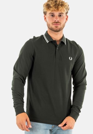 Polo de manga larga verde oscuro con cuello de canalé que presenta rayas blancas y un pequeño logo bordado en el lado izquierdo del pecho.