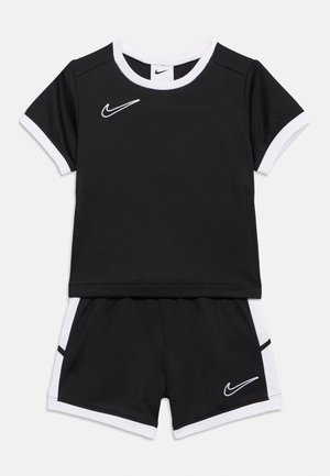 Svart-hvite Nike sportsshorts og kortermet topp med hvite kanter og swoosh-logoer på brystet og shortsen.