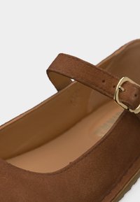 Καφέ σουέντ παπούτσι Mary Jane με χρυσή αγκράφα στον ρυθμιζόμενο ιμάντα και λείο ταμπά εσωτερικό πάτο.