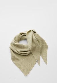 Écharpe triangulaire tricotée beige clair pliée, avec une extrémité pointue montrant une petite étiquette en tissu blanc sur fond blanc.