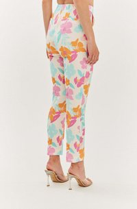 Kalhoty s květinovým vzorem v pastelových odstínech růžové, oranžové a modré; těsný střih s kapsami; zakončení u kotníků; kombinované s průhlednými podpatky.
