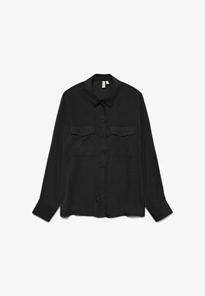 Crna košulja s dugim rukavima i kopčanjem na gumbe, šiljastim ovratnikom i dva džepa s poklopcima na prsima, prikazana ravno na bijeloj pozadini.