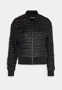 Černá prošívaná bomber bunda s předním zipem, žebrovaným límcem, manžetami a spodním okrajem, označená "DKNY Jeans" uvnitř límce.