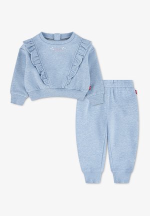 Lichtblauwe peuterset met lange mouwen en een geruffelde sweater en bijpassende broek met elastische tailleband, gemaakt van zachte stof.