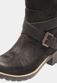Czarne zamszowe botki za kostkę o teksturowanym wykończeniu, z szerokim paskiem z klamrą oraz niskim, blokowym obcasem. Stworzona stworzona krawędź wzdłuż podeszwy.
