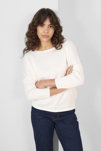Cremefarvet sweater med rund halsudskæring, 3/4 ribbede ærmer og en afslappet pasform. Sammen med mørkeblå jeans. Glat tekstur.