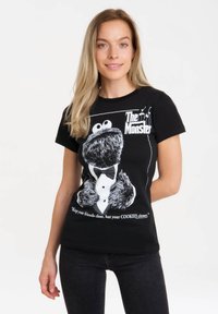 Black cotton t-shirt featuring a graphic of a furry monster in a tuxedo, with white text reading, "Keep your friends close, but your COOKIES closer."