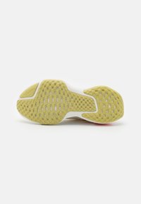 La semelle des sneakers est dotée d'une semelle en caoutchouc jaune texturé avec des motifs hexagonaux et des accents blancs, offrant adhérence et stabilité.