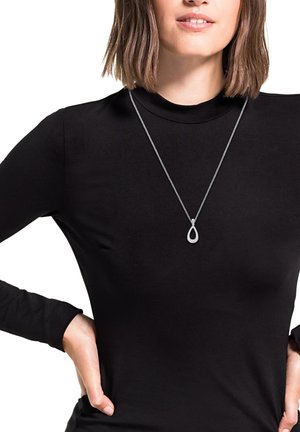 Collana con pendente d'argento a forma di goccia, posta su una delicata catena, indossata su un top a maniche lunghe nero, con una texture liscia.