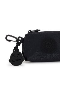 Trousse noire avec une finition texturée, dotée d'un logo rond, d'une fermeture éclair et d'un zippeur en forme de singe.