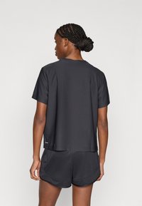 Μαύρο αθλητικό μπλουζάκι με κοντά μανίκια και στρογγυλή λαιμόκοψη, σετ με μαύρο σορτς που ταιριάζει, με λεία υφή, άνετη εφαρμογή.