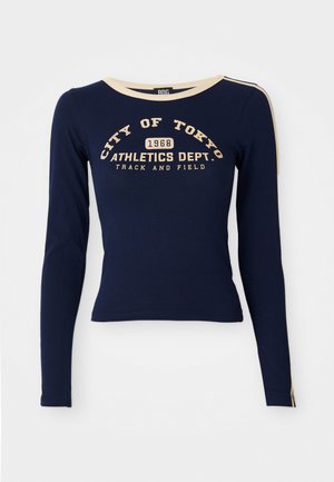 Camisa de manga larga de color marino hecha de algodón, con un cuello crema. Impresión de texto en el frente: "CIUDAD DE TOKIO 1968 DEPARTAMENTO DE ATLETISMO. PISTA Y CAMPO."